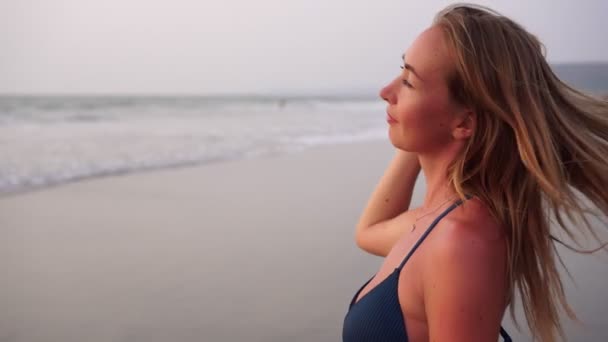Όμορφη νεαρή γυναίκα κοιτάζει τη θάλασσα. — Αρχείο Βίντεο