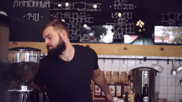 Camarero o baristo bailando en el mostrador de la cafetería. Cantinero alegre con barba — Vídeo de stock