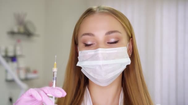 Jonge aantrekkelijke vrouwelijke schoonheidsspecialiste die een injectiespuit vasthoudt — Stockvideo
