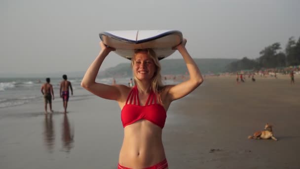 Két női szörfös bikiniben szörfdeszkával a tengerparton. Lassú mozgás.. — Stock videók
