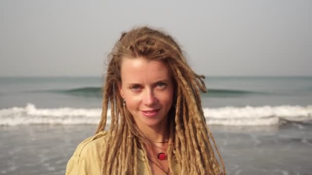 Retrato de una joven hermosa mujer con rastas sobre un fondo del mar . — Vídeos de Stock