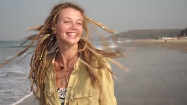 Joven mujer feliz con rastas bailando y riendo en la playa . — Vídeos de Stock