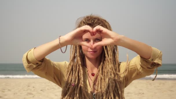 Kvinnan håller händerna vikta i form av hjärtat. Hippie flicka med dreadlocks visa kärlek. — Stockvideo