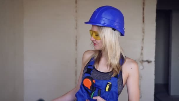 Portret van een mooie witte bouwer vrouw met een elektrische schroevendraaier — Stockvideo