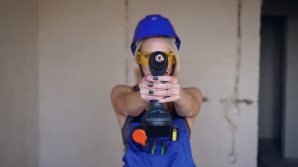 Kvinnlig byggarbetare med en elektrisk skruvmejsel. Vacker kvinna byggmästare. — Stockvideo