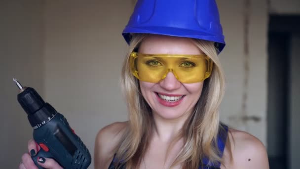 Portrait d'une femme constructrice positive gaie avec tournevis électrique — Video