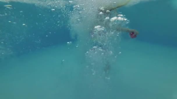 Ein Kind taucht in ein Schwimmbad ein — Stockvideo