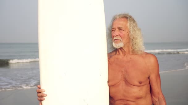 Velho com surfe. Homem idoso com prancha de surf — Vídeo de Stock