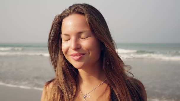 Retrato de una joven hermosa mujer feliz sobre un fondo del mar . — Vídeo de stock