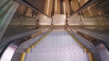 Metroda ya da havaalanında yürüyen modern bir yürüyen merdiven insan olmadan hareket eder.