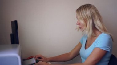 Genç bir kadın evde bilgisayarla çalışıyor. Merkez ofis konsepti, serbest çalışan.