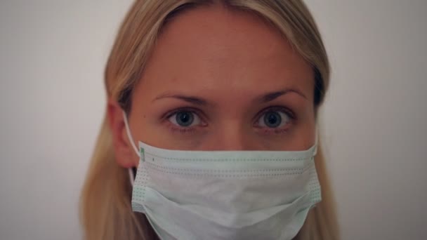 Portret van een jonge vrouw met een medisch masker. Preventie van ziekten en virussen — Stockvideo