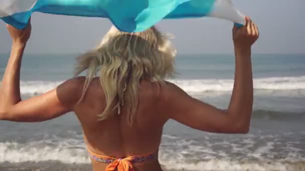 美丽的女人穿着泳衣站在一个挂满阿根廷国旗的海滩上 — 图库视频影像