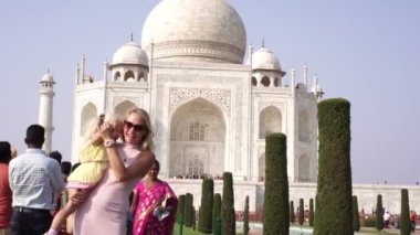 Agra, Hindistan-Mart 2020. Tac Mahal 'in arka planında çocuklu bir turist kadın.