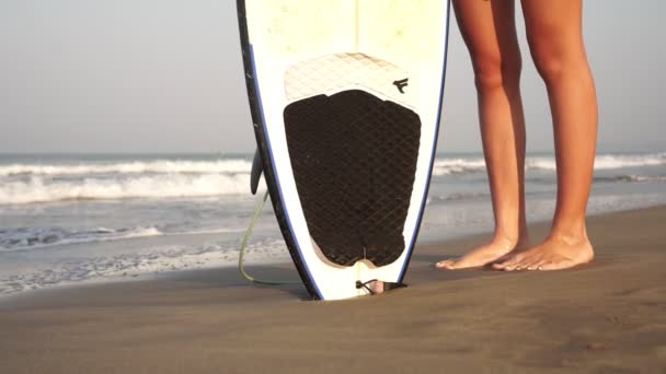 Gambe femminili, tavola da surf, onde marine e spiaggia sabbiosa — Video Stock