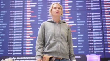 Havaalanında ya da uçuş takviminin arka planında bayan yolcu