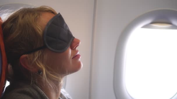 En kvinnlig passagerare sover på planet under flygningen — Stockvideo