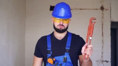 Tesisatçı portresi. Tesisat aletli bir inşaatçı