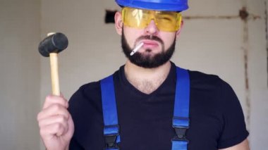 Sigaralı bir erkek müteahhit portresi. İşçi sigara içiyor.