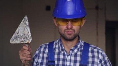 Sıvacı bir adamın portresi. İnşaat alanında çalışan bir erkek sıva ustası.