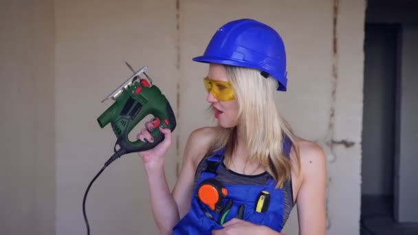 Portrait of a sexy builder woman with electric jigsaw — Stock Video