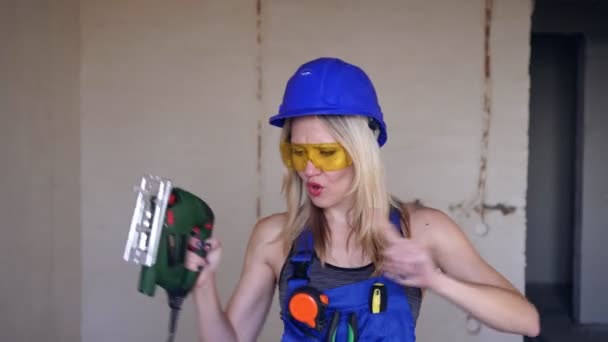 Cheerful sexy woman builder is dancing at a construction site — Stock Video