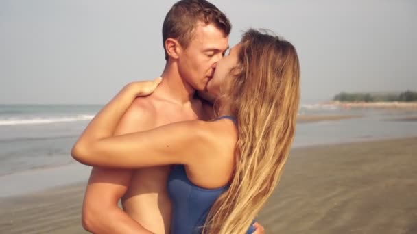 Pasgetrouwden, een jong verliefd stel zoent op het strand — Stockvideo