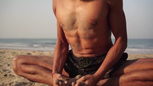 ヨガ、腹呼吸の練習。男性ヨギはビーチでヨガを練習します — ストック動画