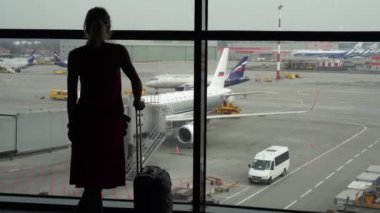 Moskova, Rusya - Mart 2020. Havaalanında uçakların arka planında bir kadın var..