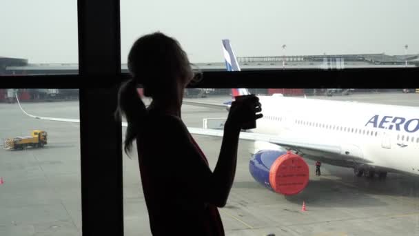 Moskau, Russland - März 2020. Silhouette einer Frau am Flughafen vor dem Fenster. — Stockvideo