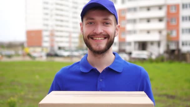 Portrait of a young attractive male courier delivery service on the street — Stock Video