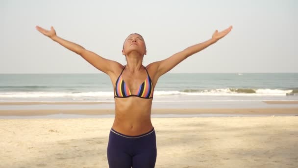 Retrato de uma bela mulher instrutora de ioga saudável na praia — Vídeo de Stock