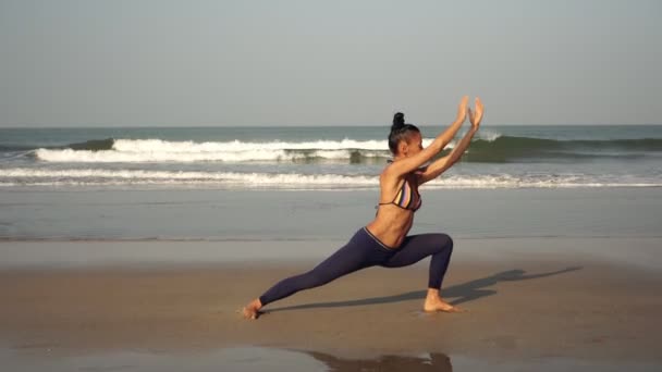 Asyalı kadın deniz sahilinde yoga yapıyor. Hindistan, Goa, bir kadın yoga yapıyor. — Stok video
