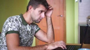 Evde dizüstü bilgisayarı olan serbest çalışan bir iş adamı. Adamın biri evde dizüstü bilgisayarla çalışıyor..