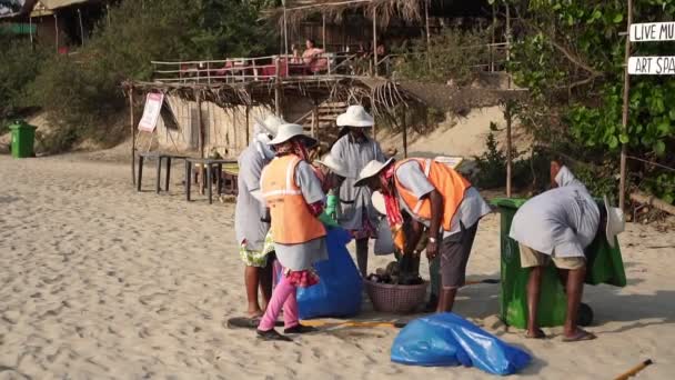 Arambol, Ινδία - Φεβρουάριος 2020. Ινδοί συλλέκτες απορριμμάτων εργάζονται στην παραλία. — Αρχείο Βίντεο