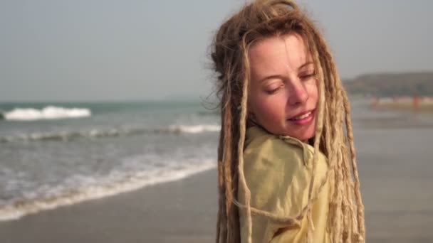 Egy fiatal, raszta hajú hippi nő sétál Goa homokos tengerpartján. — Stock videók