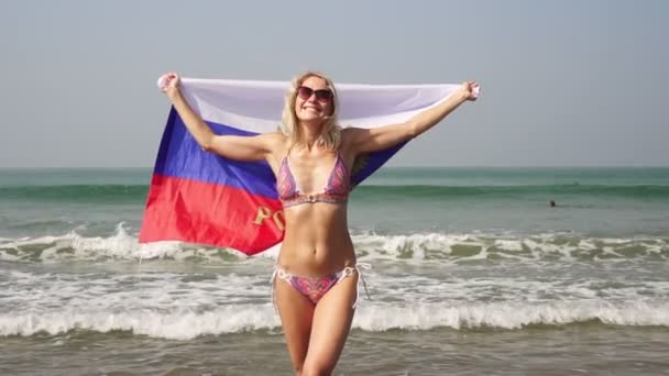 海滩上挂着俄罗斯国旗的女人穿着比基尼 海面上挂着俄罗斯国旗的女孩 — 图库视频影像