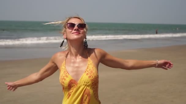 Beautiful young woman dances in the summer on the sea beach — Stock Video