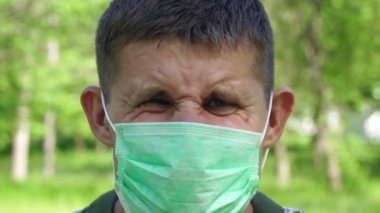 Tıbbi maskeli sinirli bir adam. Alerji ya da salgın virüs konsepti.