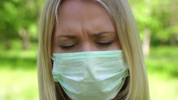 Egy szomorú nő arcképe orvosi maszkban. Boldogtalan lány orvosi védőmaszkban.. — Stock videók