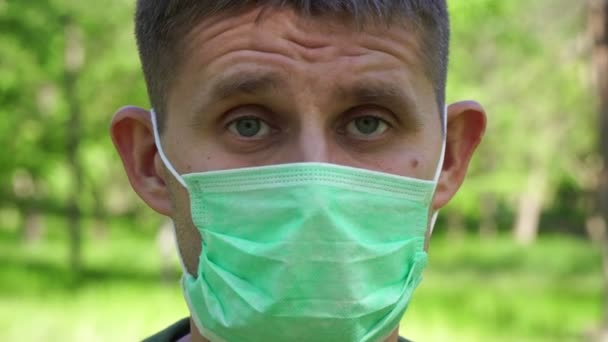 Portret van een droevige droevige man met een medisch masker. Quarantaine en coronovirus — Stockvideo