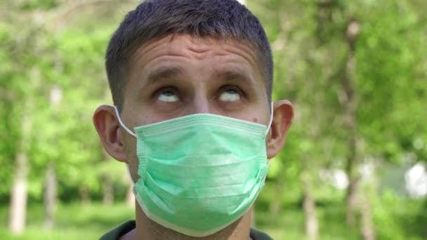 Droevige ongelukkige man met een medisch masker. Man met een beschermend masker met een droevig gezicht — Stockvideo
