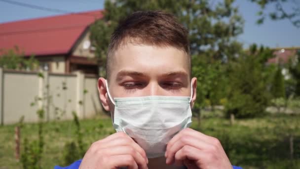 Un joven se quita la máscara médica con placer y respira hondo. — Vídeo de stock