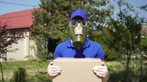 Кур'єрська служба доставки в респіраторі або газовій масці йде по вулиці — стокове відео