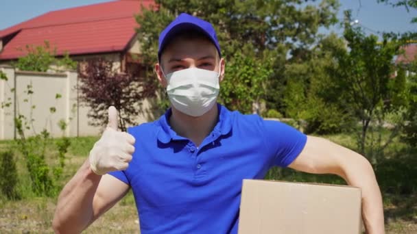 Manlig kurir från leveransservice i medicinsk mask och handskar visar tummen upp — Stockvideo