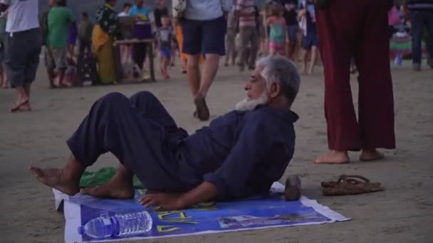 Arambol, India - 2020. február. Öreg, érett indiai férfi esténként a Goa strandon. — Stock videók