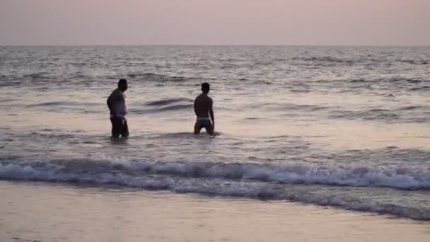 Arambol, India - febbraio 2020. Gli uomini indiani nuotano in mare sulla spiaggia di Goa . — Video Stock