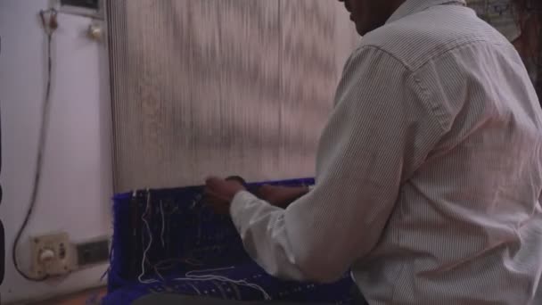 2020年2月、インドのアグラ。インドの男性の織工は伝統的な織機で働いています。織工がアジアの手作りカーペットを作る — ストック動画