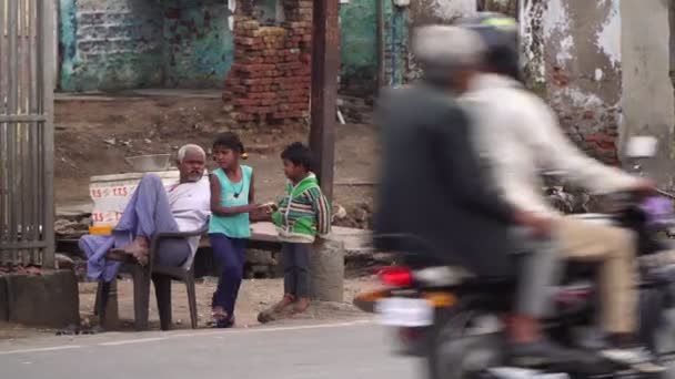 Agra, Hindistan, Şubat 2020. Yoksul Hintli ya da Asyalı çocuklar işlek bir şehir yolunun yakınında sokakta oynuyorlar.. — Stok video