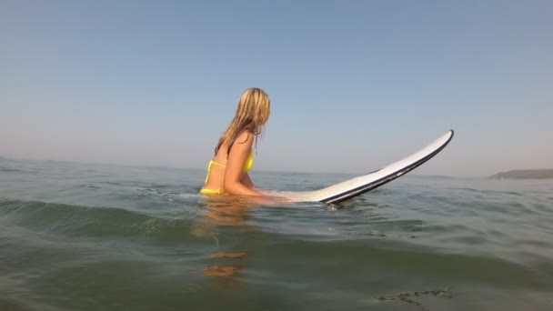 바다에서 서핑하는 매력적 인 젊은 파도타기하는 여자. 소녀 서퍼는 바다에서 파도를 기다리고 있다. — 비디오